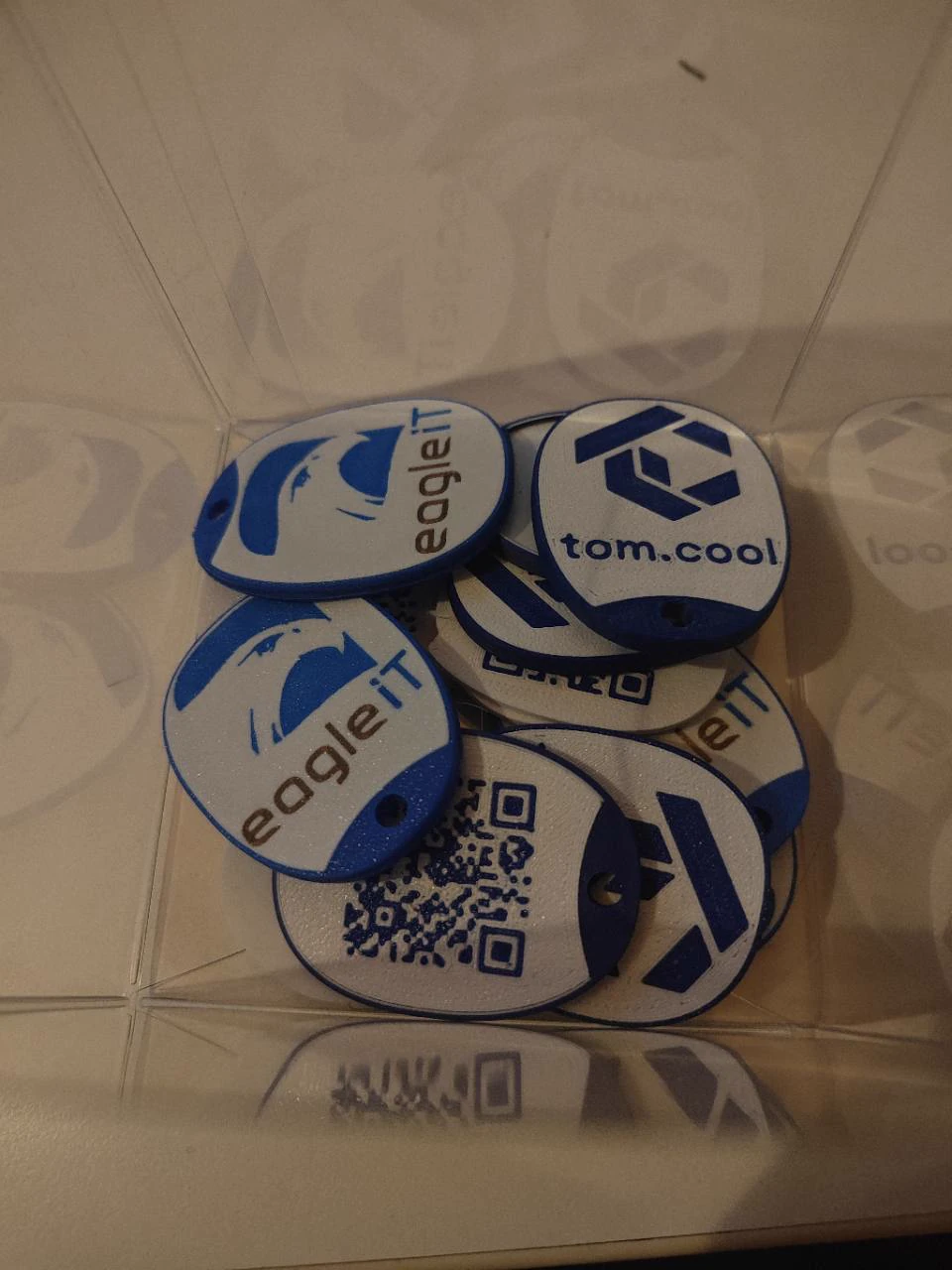 Blauw-witte sleutelhangers met logo aan de ene zijde en QR-code aan de andere